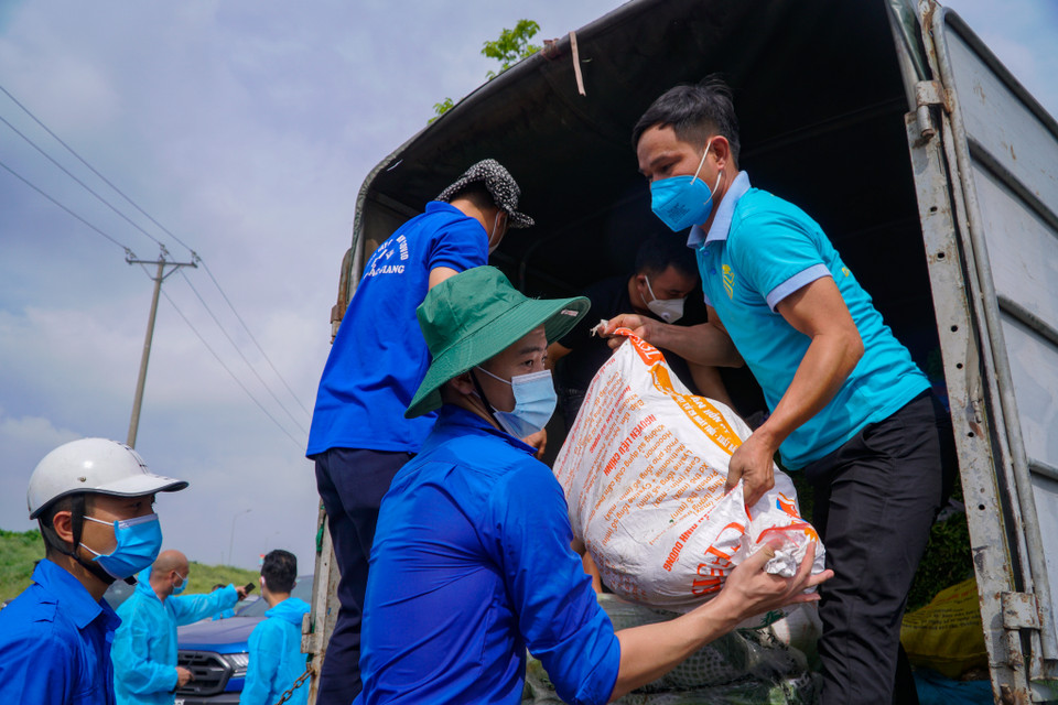 Lực lượng thanh niên xã Phù Đổng cùng thanh niên Bắc Giang hỗ trợ nhau vận chuyển nhu yếu phẩm. (Ảnh: Minh Hiếu/Vietnam+)
