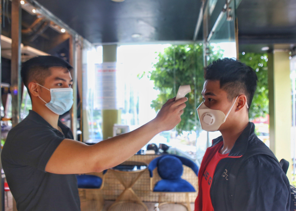 Đo thân nhiệt cho khách trước khi vào phòng tập. (Ảnh: Tuấn Đức/TTXVN)