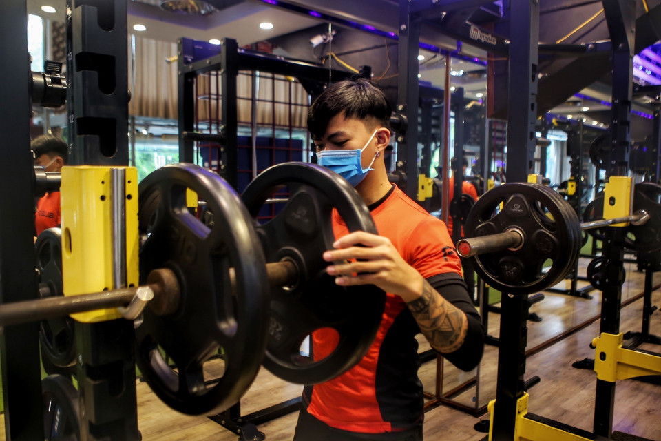 Nhân viên phòng tập sắp xếp lại dụng cụ trước khi đón khách. (Ảnh: Tuấn Đức/TTXVN)