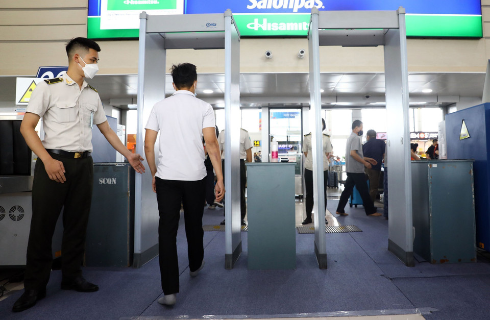 Hành khách đi qua cửa soi chiếu an ninh tại sảnh E, Sân bay Nội Bài. (Ảnh: Huy Hùng/TTXVN)