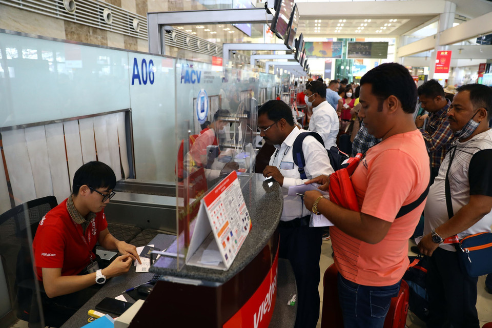 Hành khách nước ngoài làm thủ tục lên máy bay của hãng hàng không Vietjet Air. (Ảnh: Huy Hùng/TTXVN)