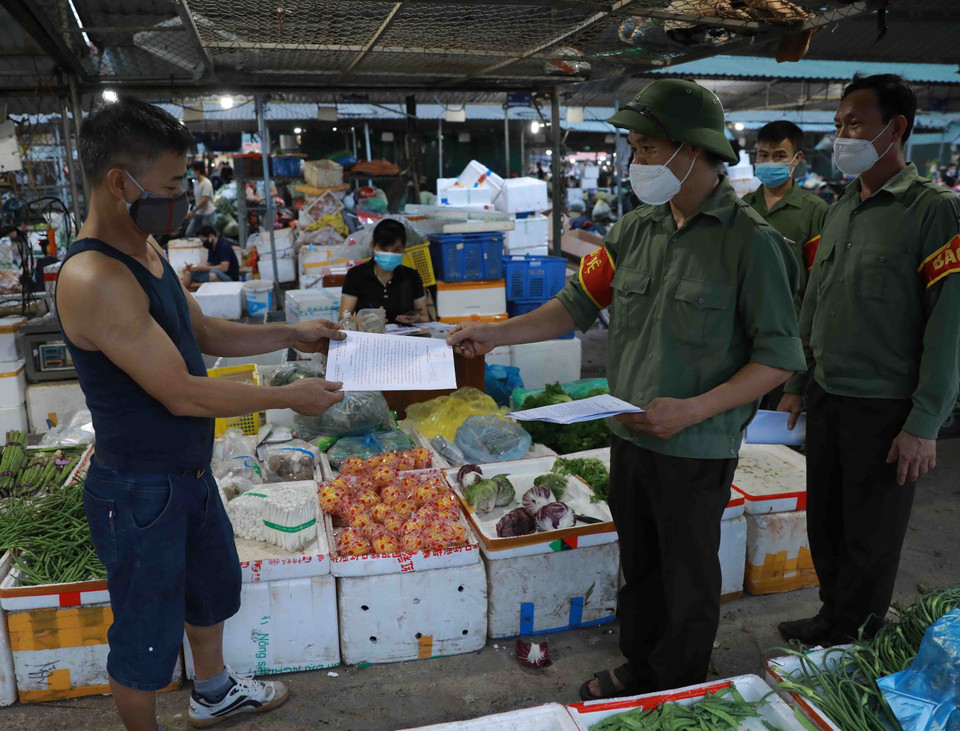 Ban Quản lý chợ đầu mối Minh Khai thường xuyên tổ chức tuyên truyền, nhắc nhở người dân thực hiện nghiêm các quy định về phòng chống dịch. (Ảnh: Vũ Sinh/TTXVN)