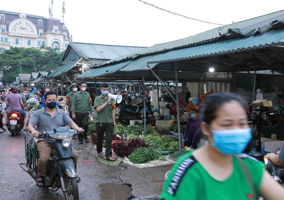 Người dân nghiêm chỉnh đeo khẩu trang khi vào chợ đầu mối Minh Khai. (Ảnh: Vũ Sinh/TTXVN)