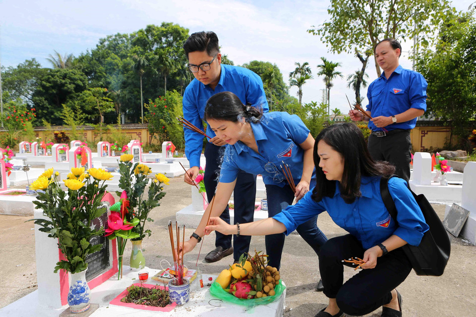 Đoàn cán bộ Thông tấn xã Việt Nam chăm sóc mộ phần các liệt sỹ của Thông tấn xã Việt Nam đã hy sinh vì sự nghiệp giải phóng dân tộc, vì độc lập và tự do của Tổ quốc. (Ảnh: Danh Lam/TTXVN)