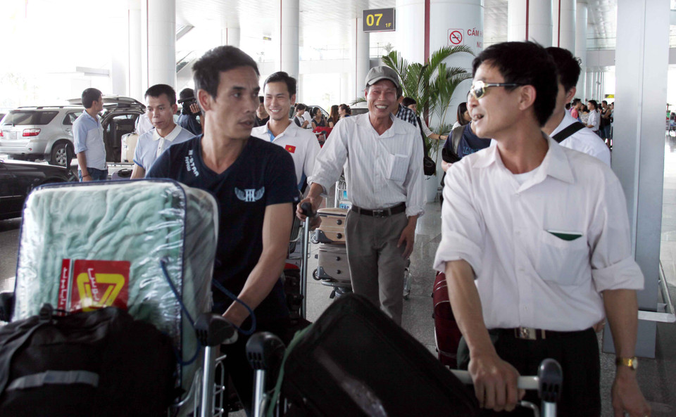 Những người lao động vui mừng khi về nước an toàn. (Ảnh: Doãn Đức/Vietnam+)