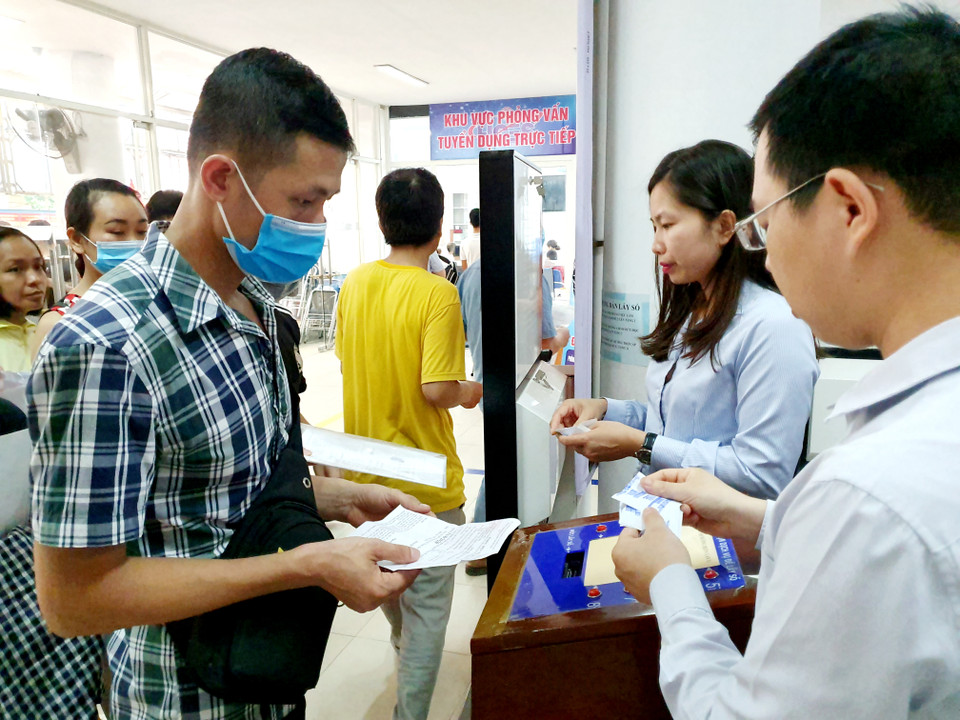 Từ sáng sớm đã có rất đông người lao động đến xếp hàng chờ lấy số. (Ảnh: Hồng Kiều/Vietnam+)