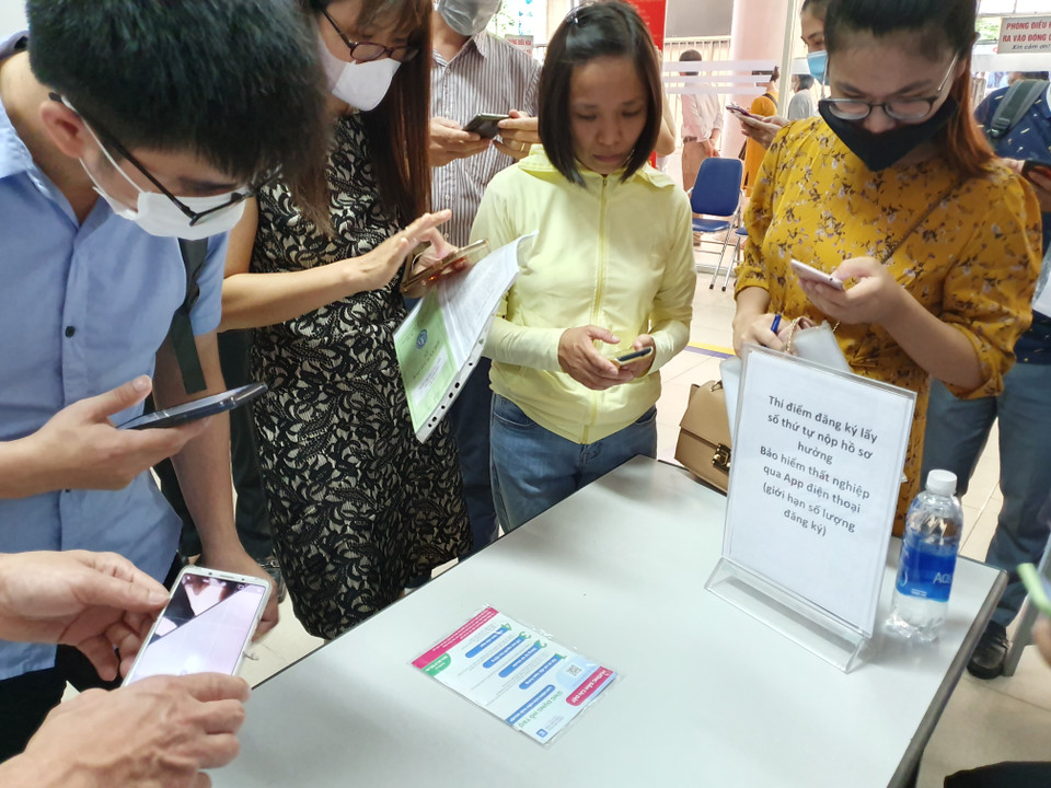 Khi hết số phát trực tiếp, người lao động tải ứng dụng để đăng ký thủ tục online. Việc đăng ký, lấy số online đang được thí điểm để tiện lợi hơn cho người lao động. Mỗi ngày, có 40 lượt hồ sơ online được giải quyết. (Ảnh: Hồng Kiều/Vietnam+)