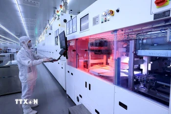 Vận hành dây chuyền sản xuất pin năng lượng mặt trời tại Công ty Trách nhiệm hữu hạn Toyo Solar, khu công nghiệp Cẩm Khê, huyện Cẩm Khê. (Ảnh: Tuấn Anh/TTXVN) 