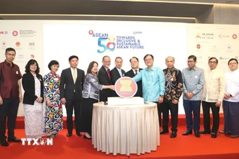 Đại diện ban tổ chức và Lãnh sự đoàn ASEAN đã cùng cắt bánh kỷ niệm 58 năm thành lập ASEAN. (Ảnh: Xuân Vịnh/TTXVN)