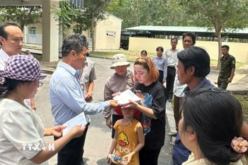 Ông Trương Vân Phong, Phó Trưởng Ban Quản lý các Khu công nghiệp Bình Dương, thăm hỏi, động viên và trao tiền hỗ trợ khẩn cấp cho các gia đình có công nhân bị nạn. (Ảnh: TTXVN phát)