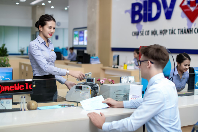 Giao dịch tại BIDV. (Ảnh: CTV/Vietnam+) BIDV dành thêm 22.300 tỷ đồng hỗ trợ doanh nghiệp bị dịch COVID-19 ảnh 1