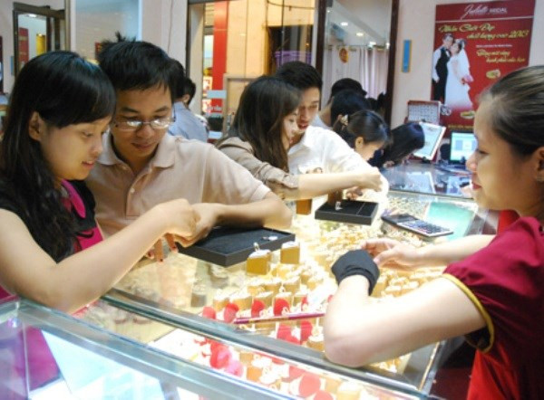 Giao dịch vàng tại Bảo Tín Minh Châu. (Ảnh: Vietnam+) Tỷ giá trung tâm tăng mạnh, giá vàng SJC không biến động ảnh 1