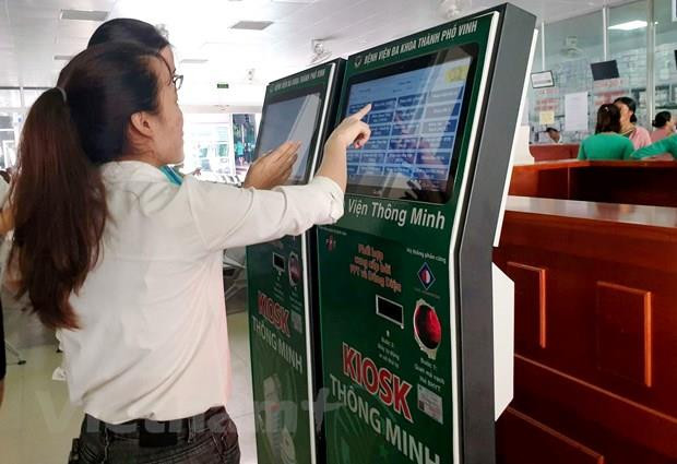 Người dân làm thủ tục với thẻ khám bệnh thông minh. (Ảnh: PV/Vietnam+) Đẩy mạnh thanh toán không dùng tiền mặt đối với dịch vụ công ảnh 1