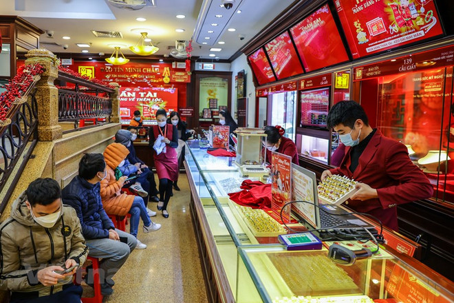 Giao dịch vàng tại doanh nghiêp. (Ảnh: Vietnam+) Giá vàng tăng mạnh ngày vía Thần Tài, giao dịch online tăng đáng kể ảnh 1