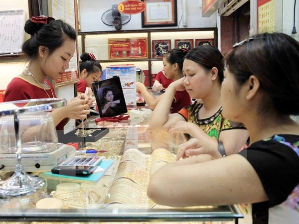 Giao dịch vàng tại doanh nghiệp. (Ảnh: TTXVN) Dù giảm, giá vàng trong nước vẫn cao hơn thế giới trên 9 triệu đồng ảnh 1