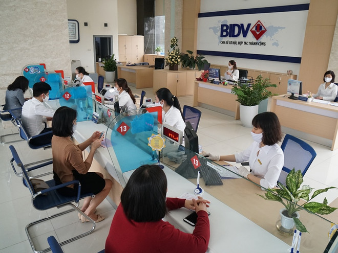 Giao dịch tại BIDV. (Ảnh: CTV/Vietnam+) BIDV miễn nhiều loại phí cho người mất việc vì COVID-19 ảnh 1
