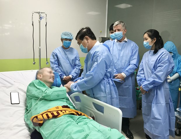 Chủ tịch Ủy ban Nhân dân Thành phố Hồ Chí Minh Nguyễn Thành Phong nói chuyện, bắt tay với bệnh nhân COVID-19 số 91. (Nguồn: TTXVN) Phi công người Anh hồi phục tốt, có thể về nước ngày 12/7 ảnh 1