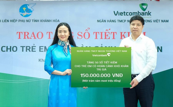 Ông Hồng Quang – Thành viên HĐQT kiêm Giám đốc Khối nhân sự, Chủ tịch Công đoàn Vietcombank trao biểu trưng 150 triệu đồng cho bà Nguyễn Quỳnh Nga - Chủ tịch Hội Liên hiệp Phụ nữ tỉnh Khánh Hòa. (Ảnh: Vietnam+) Vietcombank trao tặng 50 sổ tiết kiệm cho trẻ em mồ côi ảnh 1