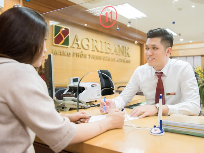 Giao dịch tại Agribank. (Ảnh: CTV/Vietnam+) Bơm vốn cho nhóm Big4: 'Gối đệm' để ngân hàng chống đỡ rủi ro ảnh 2