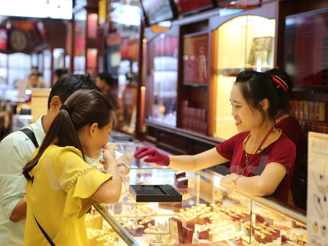 Giao dịch vàng tại Bảo Tín Minh Châu. (Ảnh: Minh Sơn/Vietnam+) Giá vàng trong nước giảm tới 500.000 đồng do ảnh hưởng của Fed ảnh 1