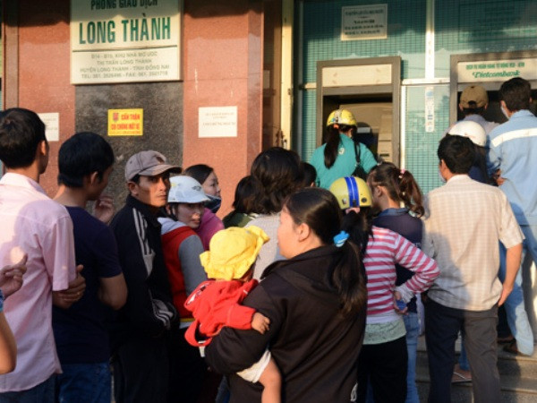 Xếp hàng dài chờ rút tiền tại cây ATM. (Nguồn: TTXVN). Tết đến Xuân về, chờ máy ATM lại lo ngay ngáy ảnh 1