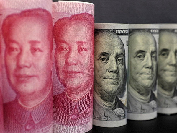 Đồng tiền giấy 100 Nhân dân tệ (trái) và đồng đôla Mỹ ở Bắc Kinh. (Nguồn: Reuters/ TTXVN) Tổng thống Mỹ cáo buộc Nga và Trung Quốc phá giá đồng tiền ảnh 1