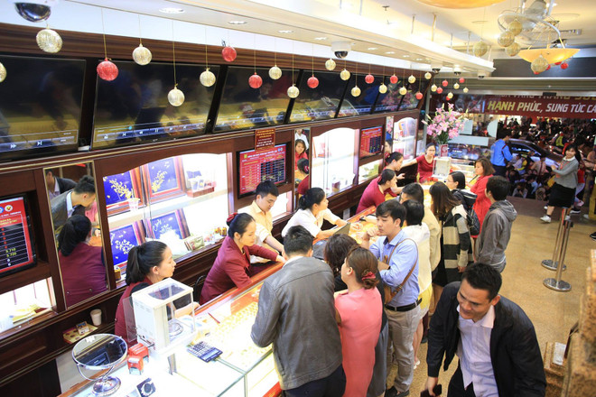 Giao dịch vàng tại các doanh nghiệp. (Ảnh: PV/Vietnam+) Hai thương hiệu vàng trong nước tiếp tục giảm, tỷ giá trung tâm tăng ảnh 1