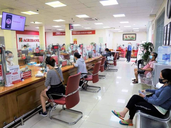Giao dịch tại Agribank. (Ảnh: CTV/Vietnam+) Năm 2022: Xu hướng lãi suất ở mức ổn định, nỗ lực có thể giảm thêm ảnh 1