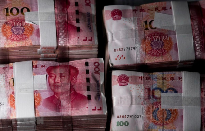 Đồng tiền mệnh giá 100 nhân dân tệ tại Thượng Hải, Trung Quốc. (Ảnh: AFP/TTXVN) Chuyên gia dự đoán Trung Quốc tiếp tục nới lỏng chính sách tiền tệ ảnh 1