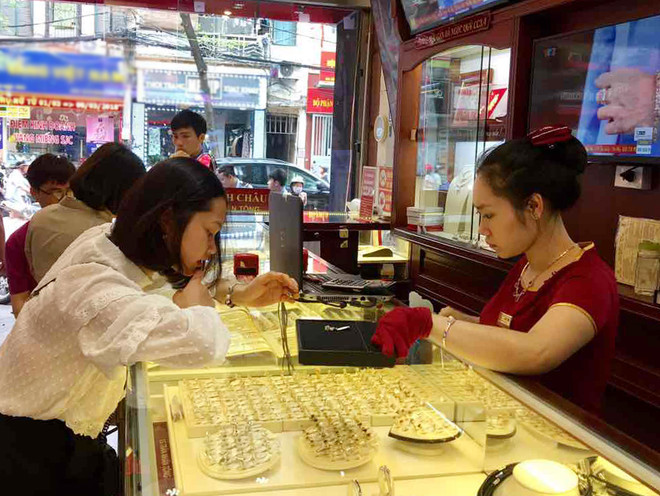 Giao dịch vàng tại các doanh nghiệp. (Ảnh: PV/Vietnam+) Hai thương hiệu vàng trong nước giảm giá nhẹ phiên đầu tuần ảnh 1