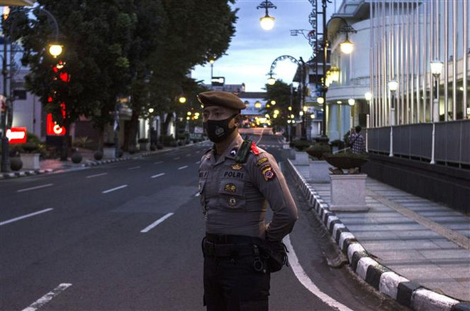 Cảnh sát Indonesia gác trên một đường phố ở Bandung, Tây Java, Indonesia. (Ảnh: THX/TTXVN) Dịch viêm đường hô hấp cấp COVID-19: Châu Á nỗ lực ngăn chặn dịch bệnh ảnh 1