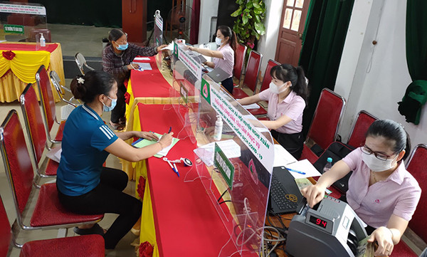 Giao dịch tại Ngân hàng Chính sách xã hội chi nhánh Hà Tĩnh. (Ảnh: Vietnam+) Vốn tín dụng chính sách - động lực giúp Hà Tĩnh giảm nghèo nhanh ảnh 1