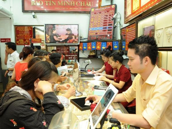 Giao dịch vàng tại Bảo Tín Minh Châu. (Ảnh: Minh Sơn/Vietnam+) Giá vàng SJC tăng nhẹ, chênh lệch với thế giới gần 5 triệu đồng ảnh 1