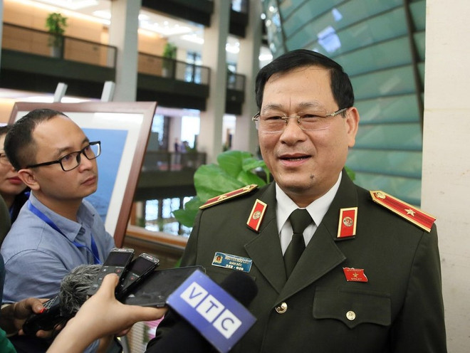 Thiếu tướng Nguyễn Hữu Cầu trả lời báo chí bên hành lang Quốc hội. (Ảnh: PV/Vietnam+) Giám đốc công an nói về vụ bắt 8 đối tượng nghi đưa người sang Anh ảnh 1
