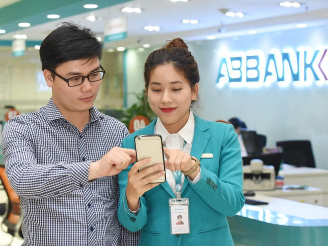 Cán bộ ABBANK hướng dẫn khách hàng gửi tiết kiệm online. (Ảnh: CTV) ABBANK tặng thêm 0,2% lãi suất tiền gửi tiết kiệm online ảnh 1