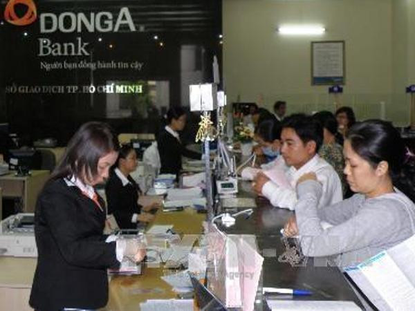 Giao dịch tại DongABank. (Nguồn: TTXVN) Nguyên Tổng giám đốc DongABank Trần Phương Bình bị bắt ảnh 1
