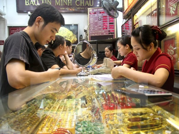 Khách hàng đang giao dịch vàng miếng. (Ảnh: TTXVN) Tỷ giá và giá vàng tiếp tục trượt giảm ở phiên cuối tuần ảnh 1