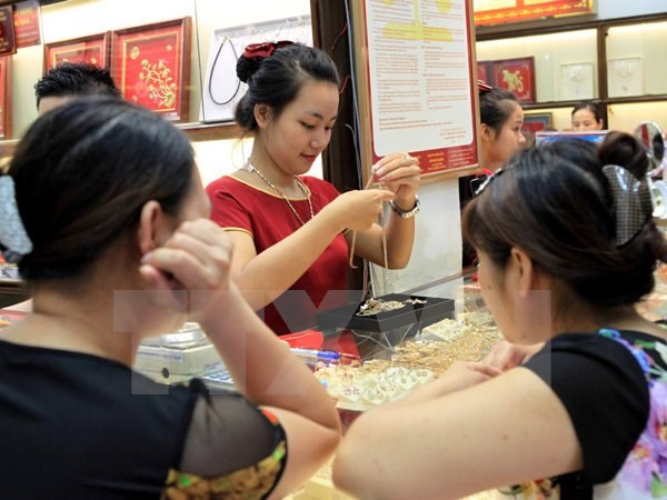 Giao dịch vàng tại doanh nghiệp. (Nguồn/TTXVN) Giá vàng SJC điều chỉnh không đồng nhất, tỷ giá USD tiếp tục tăng ảnh 1