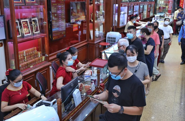 Giao dịch vàng tại doanh nghiệp. (Ảnh: Vietnam+) Vàng SJC không biến động, tỷ giá trung tâm tiếp tục tăng 11 đồng ảnh 1