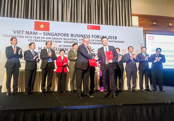 Đại diện Vietcombank, ông Phạm Quang Dũng, Tổng Giám đốc (hàng đầu, bên phải) và đại diện SBF, ông Ho Meng Kit – Giám đốc điều hành ký kết thỏa thuận hợp tác giữa hai bên. (Nguồn: Vietcombank) Vietcombank ký kết hợp tác với Liên đoàn doanh nghiệp Singapore ảnh 1