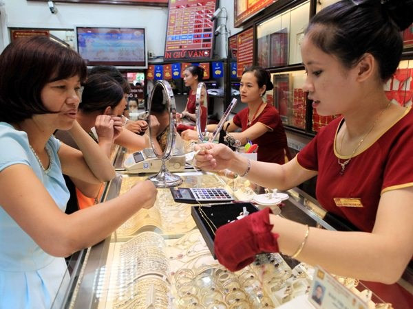 Giao dịch vàng tại Bảo Tín Minh Châu. (Nguồn: TTXVN) Hai thương hiệu vàng trong nước giảm đến 130.000 đồng sau nghỉ lễ ảnh 1