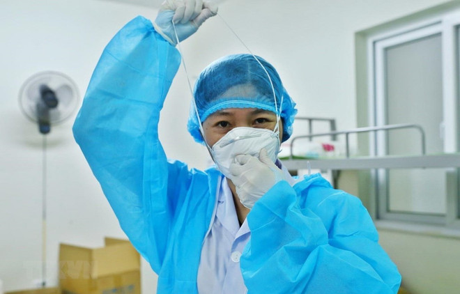 Bác sỹ chuẩn bị đồ bảo hộ vào phòng bệnh nhân COVID-19. (Ảnh: Minh Quyết/TTXVN) 59 ngày không COVID-19, bệnh nhân 91 đã ăn được qua đường tiêu hóa ảnh 1
