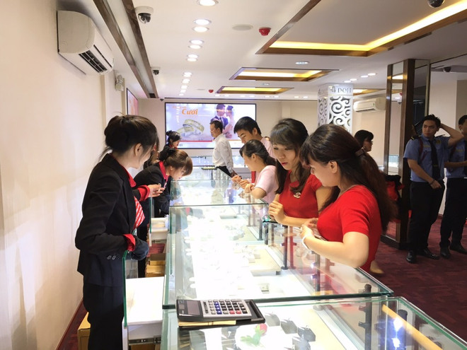 Giao dịch vàng tại Doji. (Ảnh: CTV/Vietnam+) Giá vàng trong nước và thế giới tăng giảm ngược chiều nhau ảnh 1