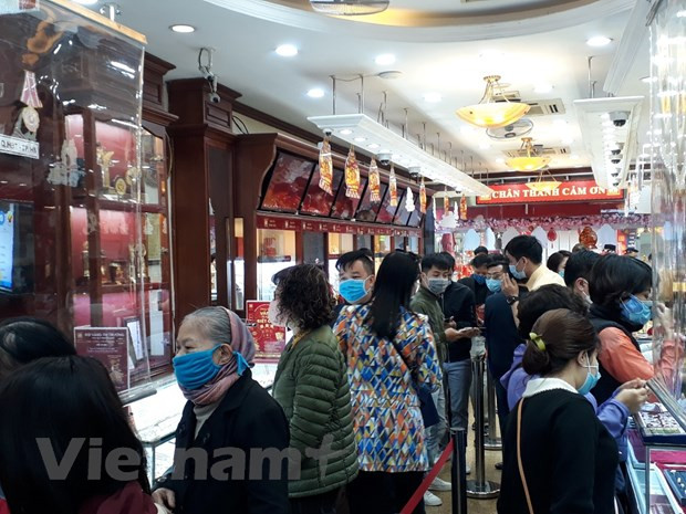 Giao dịch vàng tại doanh nghiệp. (Ảnh: Vietnam+) Giá vàng SJC và tỷ giá trung tâm cùng tăng phiên ngày 18/1 ảnh 1