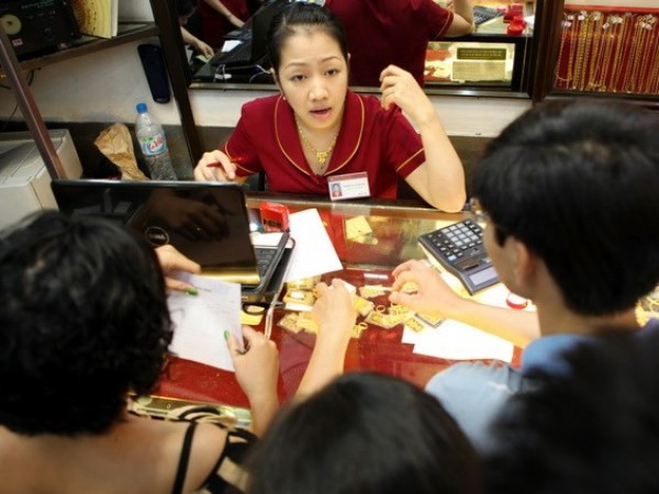 Giao dịch vàng tại Bảo Tín Minh Châu. (Nguồn: TTXVN) Thương hiệu Rồng Thăng Long tiếp tục tăng, vàng thế giới bất ngờ giảm ảnh 1