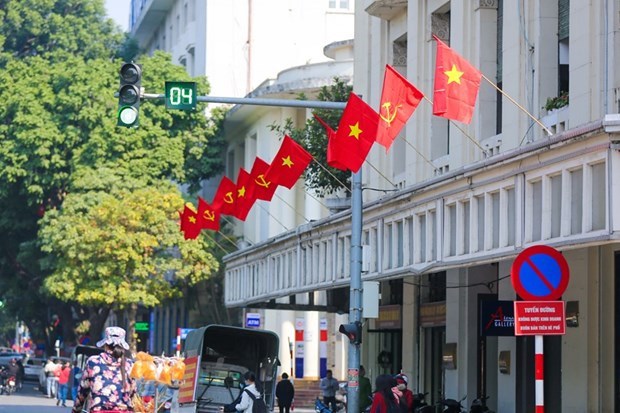 Các ngả đường rực rỡ sắc màu đỏ thắm của cờ và hoa. (Ảnh: Minh Sơn/Vietnam+) Đại hội XIII của Đảng: Dấu mốc định hình tương lai đất nước ảnh 2