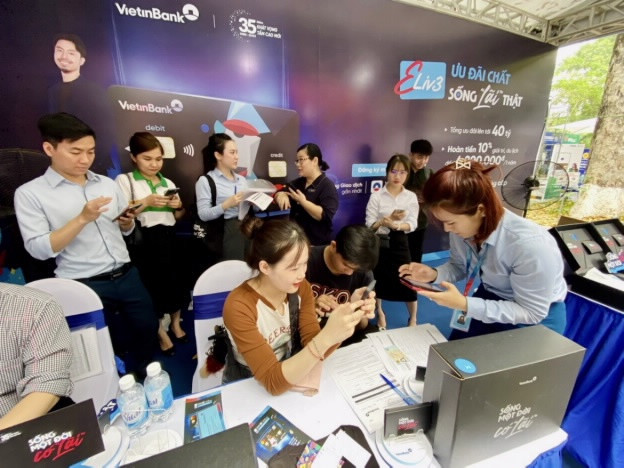 Các bạn trẻ hào hứng trải nghiệm tại triển lãm. (Ảnh: Vietnam+) Nâng cao kiến thức, kỹ năng về tài chính, ngân hàng cho giới trẻ ảnh 1