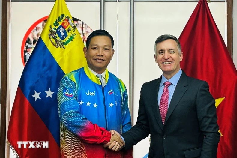Đại sứ Vũ Trung Mỹ mặc áo đội tuyển Olympic quốc gia Venezuela do Bộ trưởng Franklin Cardillo trao tặng. (Ảnh: ĐSQ cung cấp)