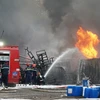 Gió to khiến ngọn lửa bùng phát mạnh, đám cháy phát ra nhiều tiếng nổ lớn. (Ảnh: Quốc Dũng/TTXVN)