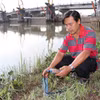 Đo độ mặn bên trong cống Bông Bót (xã An Phú Tân, Vĩnh Long) để đóng, mở cống phù hợp. (Ảnh: Thanh Hòa/TTXVN)
